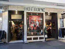 The Hot Topic storefront in the Oak Park Mall. White brick surrounds two doors, which flank the sides of a tall window in the center.