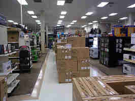 The home entertainment section of Micro Center. Monitor boxes line the walkway, with shelves to the left and right.