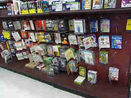 A peg board with boxed software in Micro Center. Software on this wall includes anti-virus, website design, finance, and home office software.