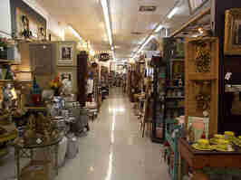 A walkway in the Glenwood Antique Mall. The sides are lined with tightly-packed booths, each containing various collectibles.
