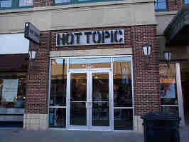 The Hot Topic storefront in Zona Rosa. The company's logo is above glass doors, surrounded by brown brick.