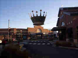 An intersection in the Zona Rosa. A store is on the right, and an empty building is in the background. A large crown is suspended over the intersection.